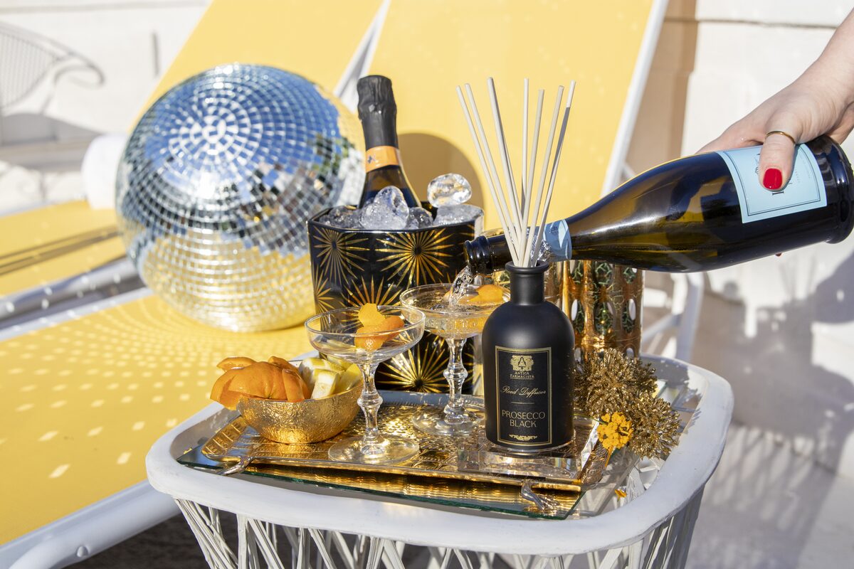 Champagne mid-pour over coupes beside the Prosecco Black diffuser and a disco ball.