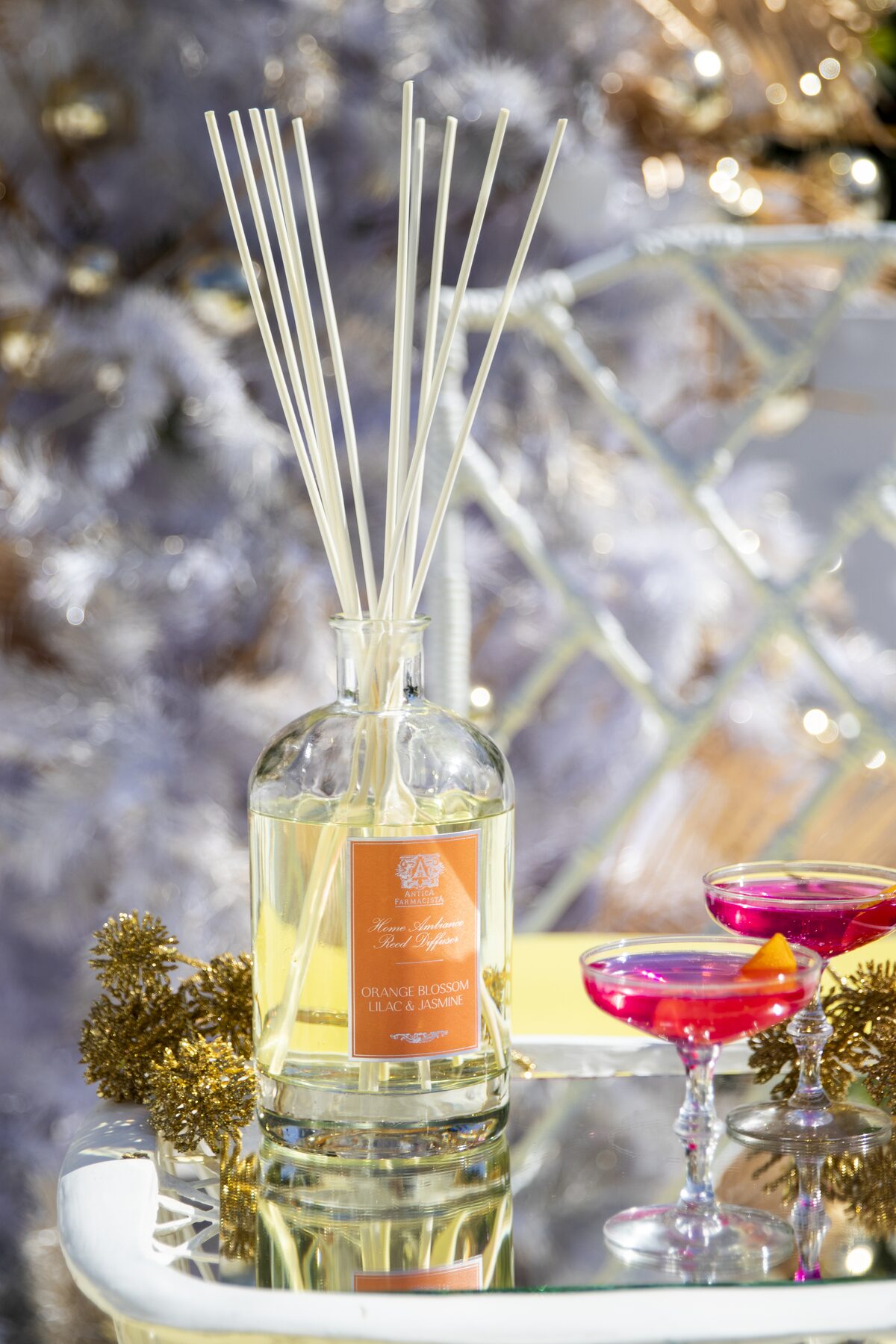 The Orange Blossom diffuser and pink cosmos in coupes beneath the white Christmas tree.