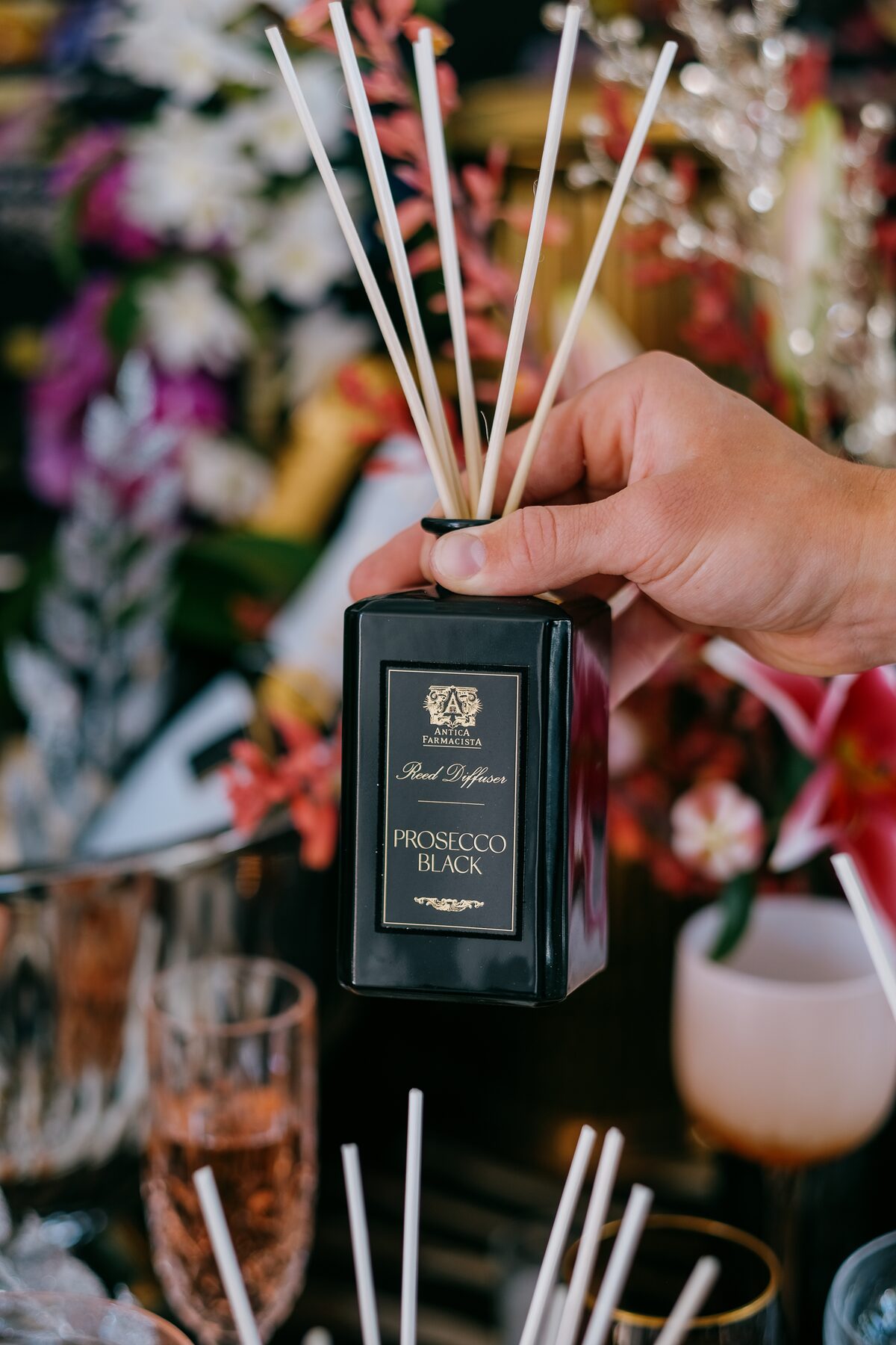 The Prosecco Black box held against stargazer lilies and blush glassware.