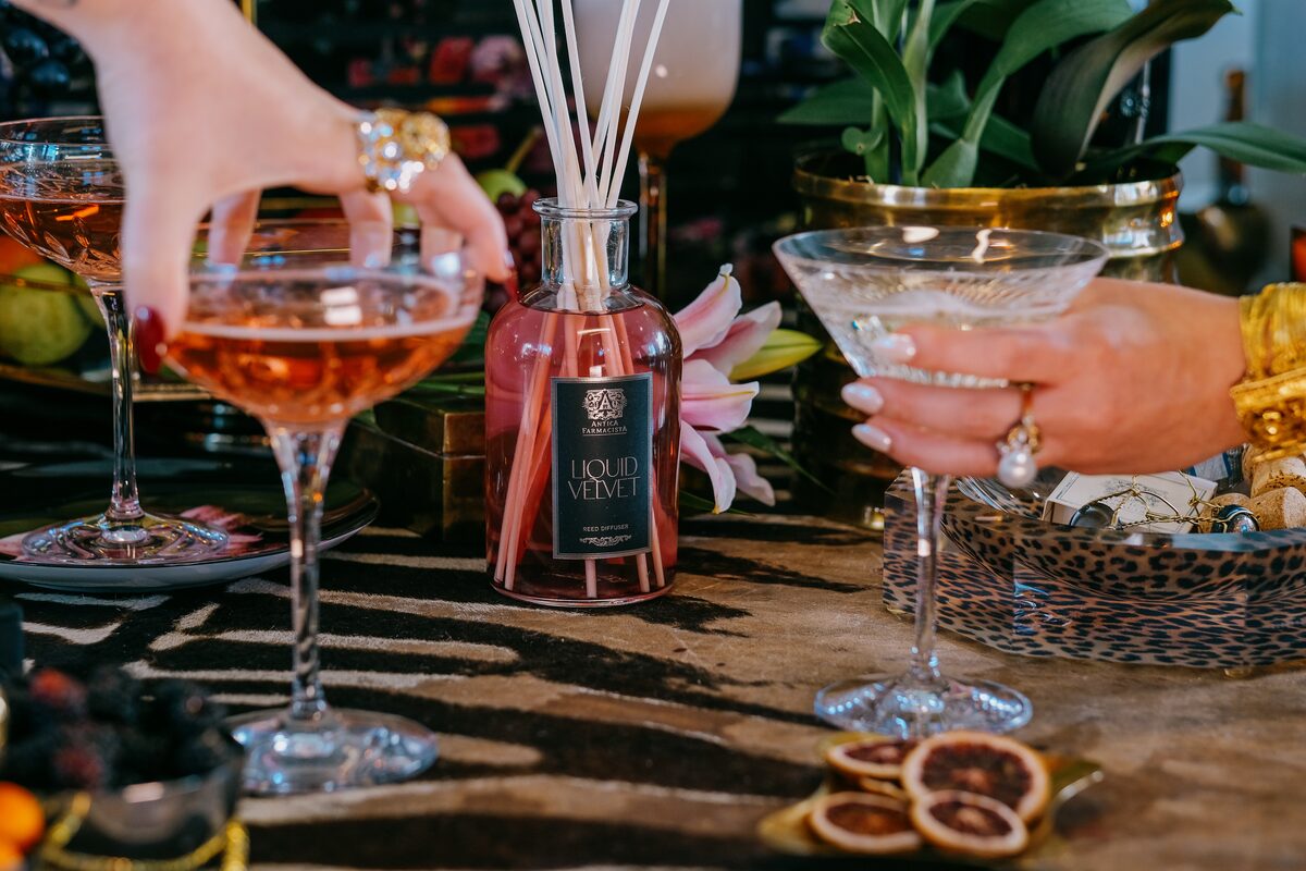 A cosmopolitan lifted past the Velvet diffuser, gilded vases and greenery behind.