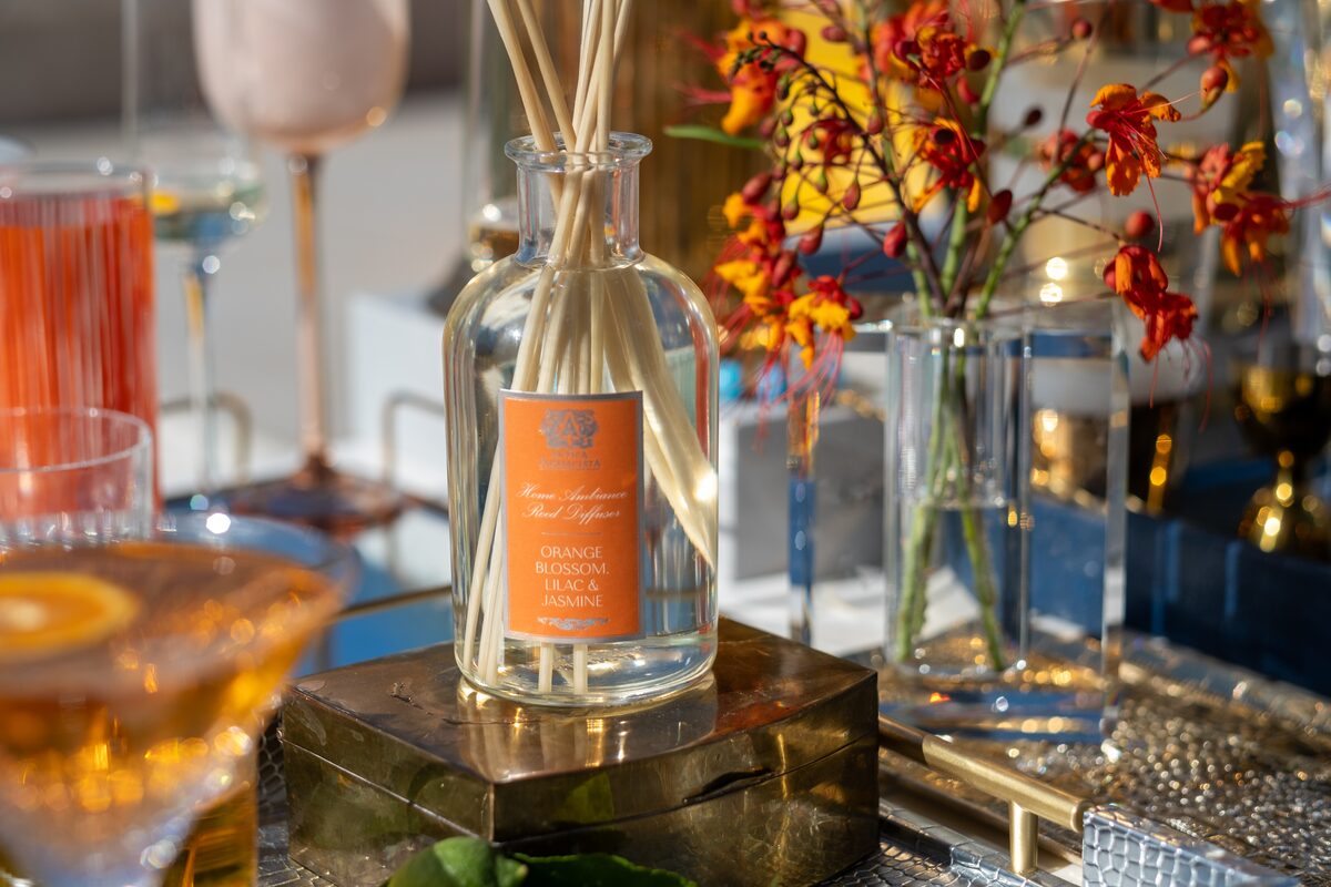 The Orange Blossom diffuser with a scarlet cocktail and orchids at the cart.
