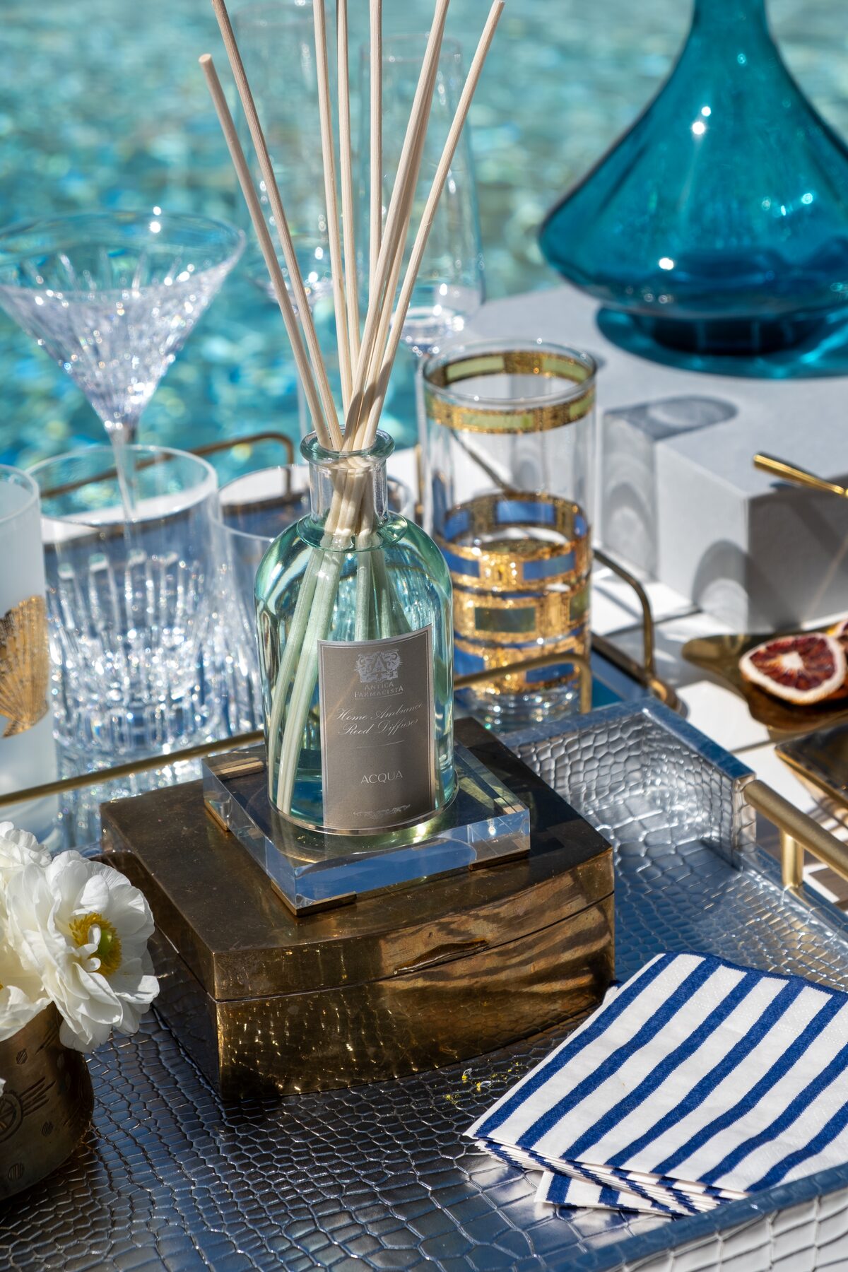 The Acqua diffuser with figs and a striped napkin, cool morning light.