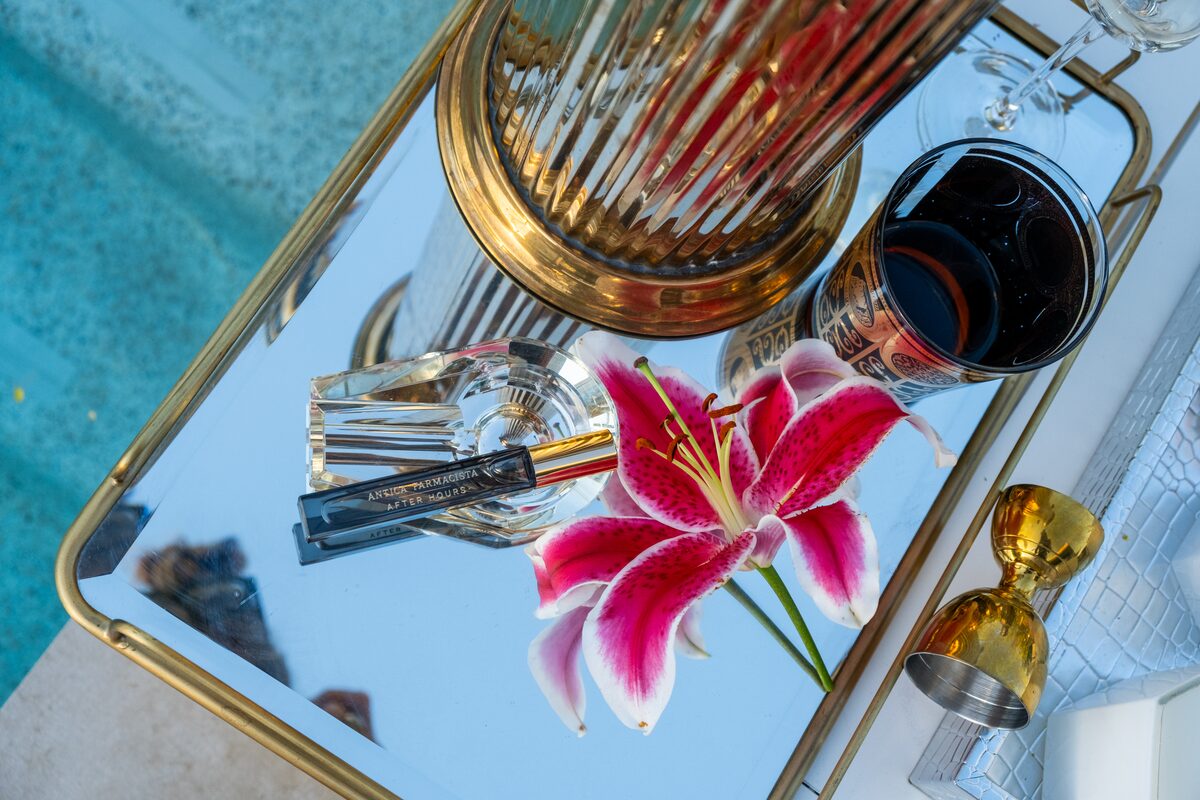 The mirrored tray catching a stargazer lily, minis and gold in its reflection.