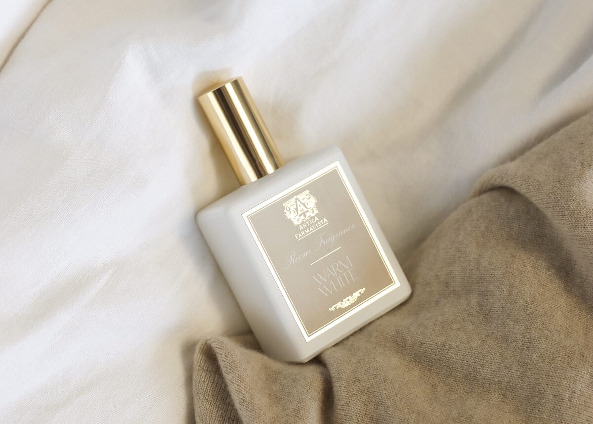 The gold-capped room fragrance nestled into a waffle-knit cashmere throw.